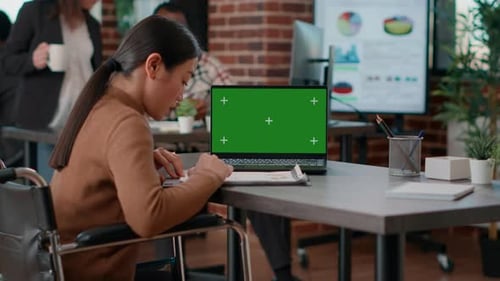 Adult Working on Laptop with Green Screen in Office