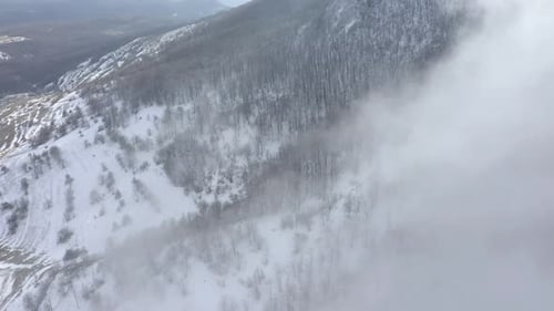 Fast moving fog over the forest on mountain top 4K drone video