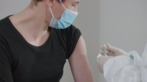 Medical Professional Administers Injection to Adult
