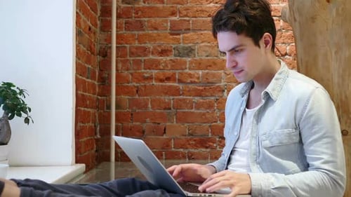Man Works on Laptop, Expresses Frustration and Relief
