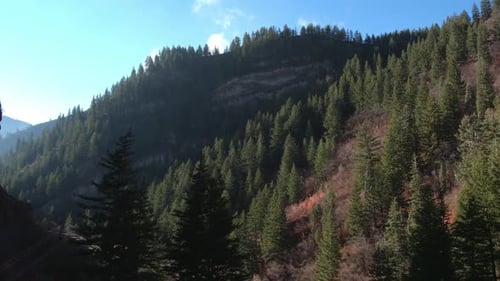 Aerial view flying from within a deep canyon towards mountain top