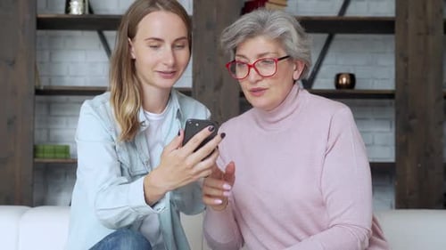 Two Women Watching a Mobile Phone Together