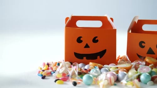 Halloween-Box mit verschiedenen Süßigkeiten auf weißem Hintergrund 4k