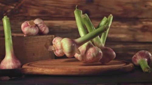 Super Zeitlupe Knoblauch fällt auf ein Schneidebrett auf einem Holzuntergrund