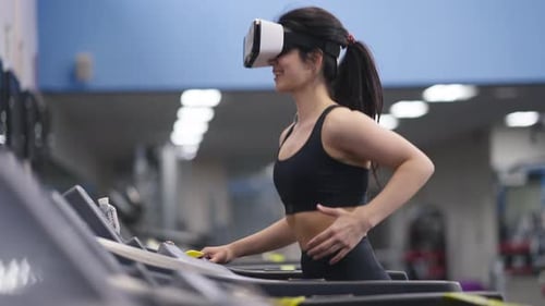 Woman Using VR Treadmill in a Modern Gym