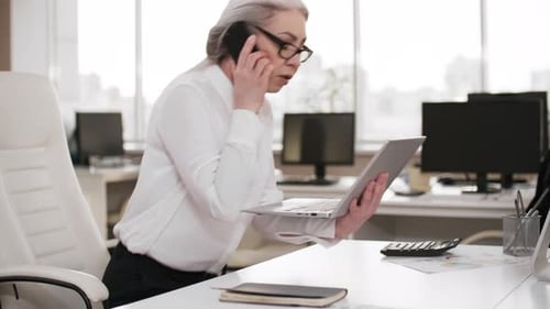 Middle-Aged Caucasian Female Careerist Working Alone in Empty Office