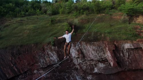 Man Walking Tightrope Above Rocky Nature Ridge