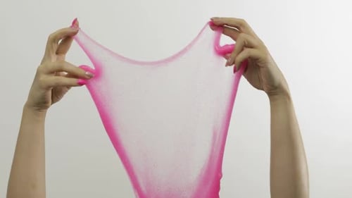 Woman Hands Playing Oddly Satisfying Pink Slime on White Background. Antistress