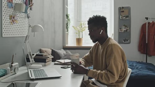Young Adult Working at Home with Laptop