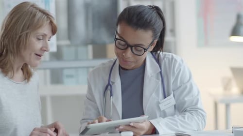 Doctor Showing Tablet to Patient in Bright Office