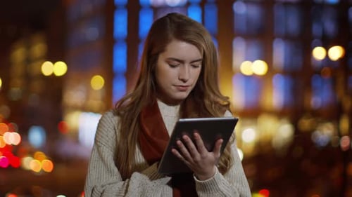 Woman Using Tablet at Night in City