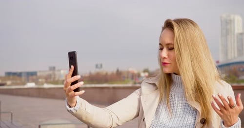 Woman Talking on Phone During Video Call in City