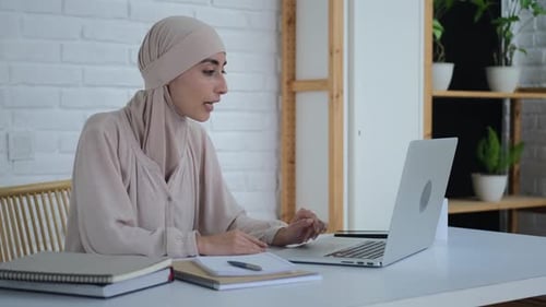 Woman Video Calling Using Laptop at Home