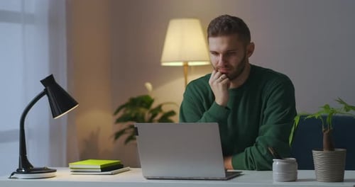 Adult Man Is Viewing Video or Cinema on Display of Notebook at Home at Evening Learning and