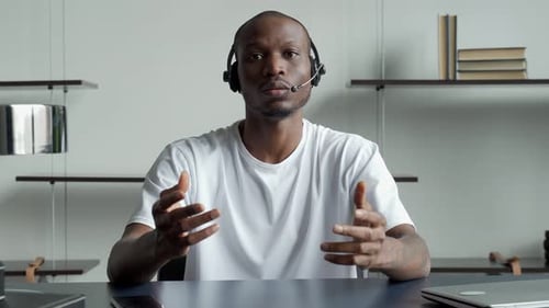 Young Man Explaining on Video Call with Headset