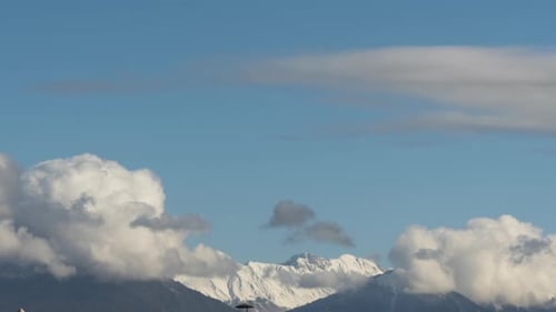 Clouds Drifting Over Snowy Mountain Range