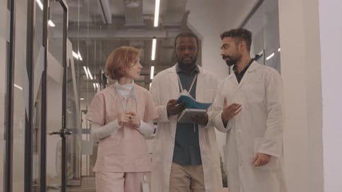 Medical Team Walking and Talking in Hospital Hallway