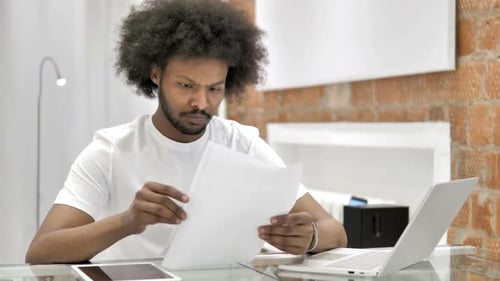 Adult Reading Paper Document at Home Office Desk