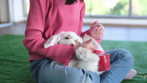 Child Cuddling White Rabbit with Easter Eggs