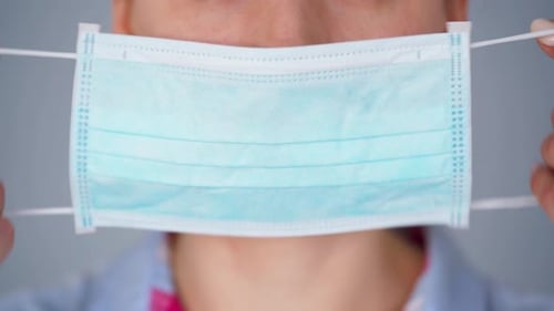 Close Up of Person Putting on Surgical Mask