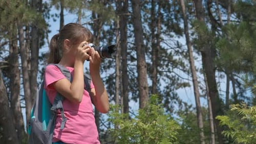 Girl Taking Pictures in a Forest with Camera