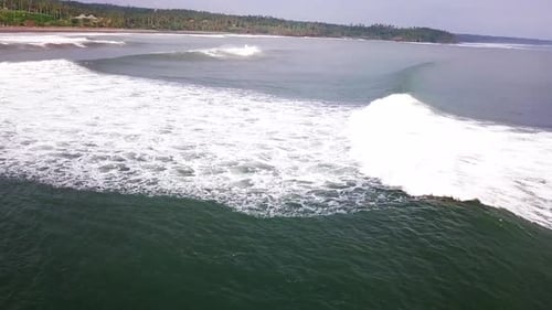 Aerial Shot of Foaming Waves Rolling onto Shore