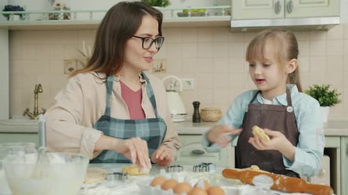 Mother and Daughter Baking Cookies Together in Kitchen
