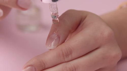 Woman Applying Cuticle Oil to Nails