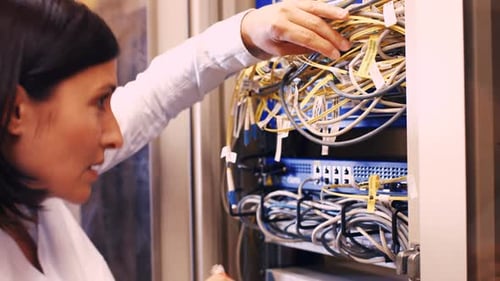 Techniker überprüft Kabel in einem im Rack montierten Server