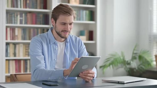 Man Using Tablet While Sitting in Office
