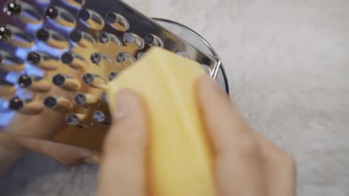 Man Rubs Hard Grated Cheese and Cheese Crumbles