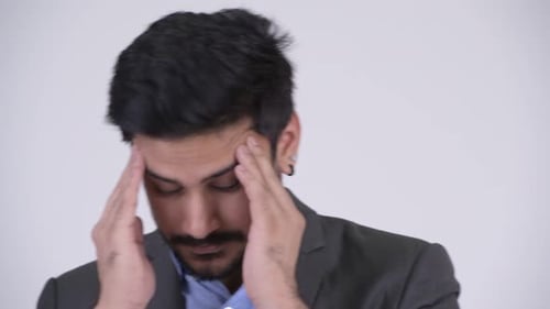 Stressed Man Massages Temples in Studio Setting