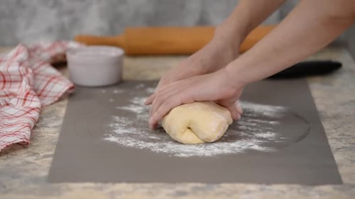 Frauenhände kneten den Teig.