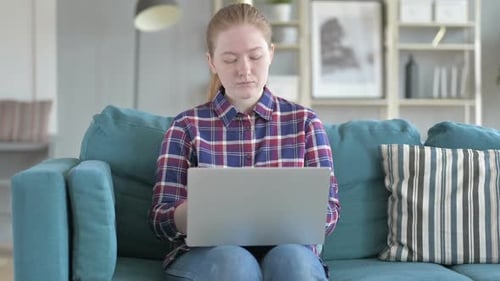 Woman Works on Laptop At Home on Couch