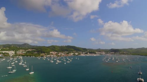 Green mountains and boats moored at marina harbor, Le Marin