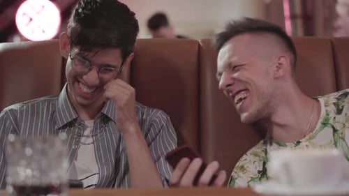 Portrait of Two Male Friends Resting in the Restaurant Sitting on the Leather Sofa