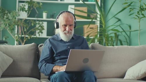 Senior Man Using Laptop on Couch at Home