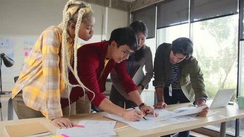 Team Collaborating on Charts at Office Table