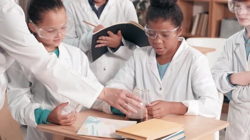 Students Conduct Science Experiment in Classroom with Teacher