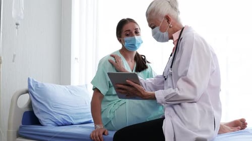 Doctor Consults Patient with Tablet in Hospital Room