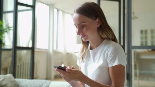 Woman Using Phone Indoors During Daytime