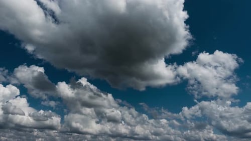 Billowing White Clouds Float Across Blue Sky