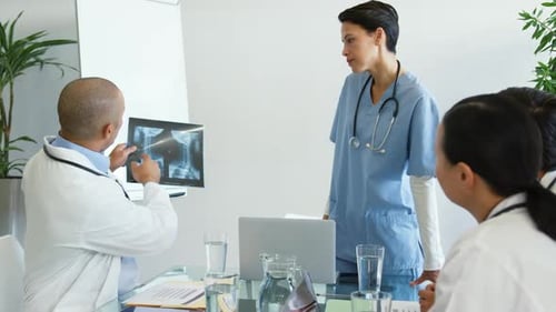 Medical Professionals Discussing X-Ray Results in Meeting