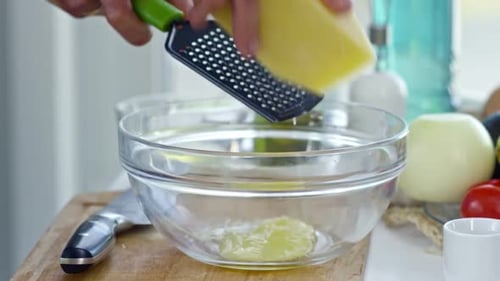 Grating Cheese into a Bowl of Liquid