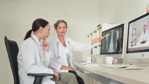 Two Doctors Discuss X-ray on a Computer Monitor
