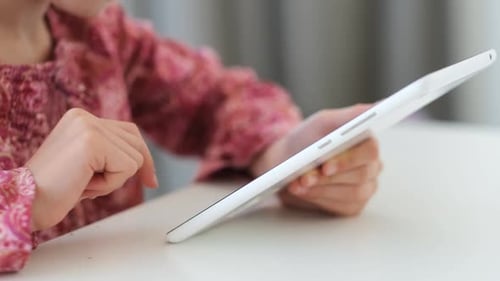 Child Using Tablet at Table Close Up