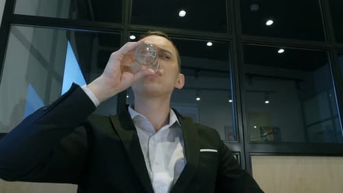 A Successful Young Man Working. Happy Businessman Works In Private Office And Drinks A Water