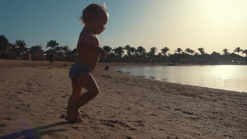Active Little Boy Sunbathing on Beautiful Seaside. Sweet Child Playing at Beach.