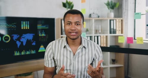 Gerente de oficina afroamericana que graba Vídeo para espectadores de Internet con el pulgar hacia arriba