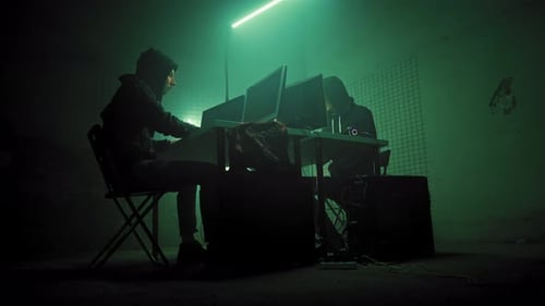 People Coding on Computers in Dimly Lit Room